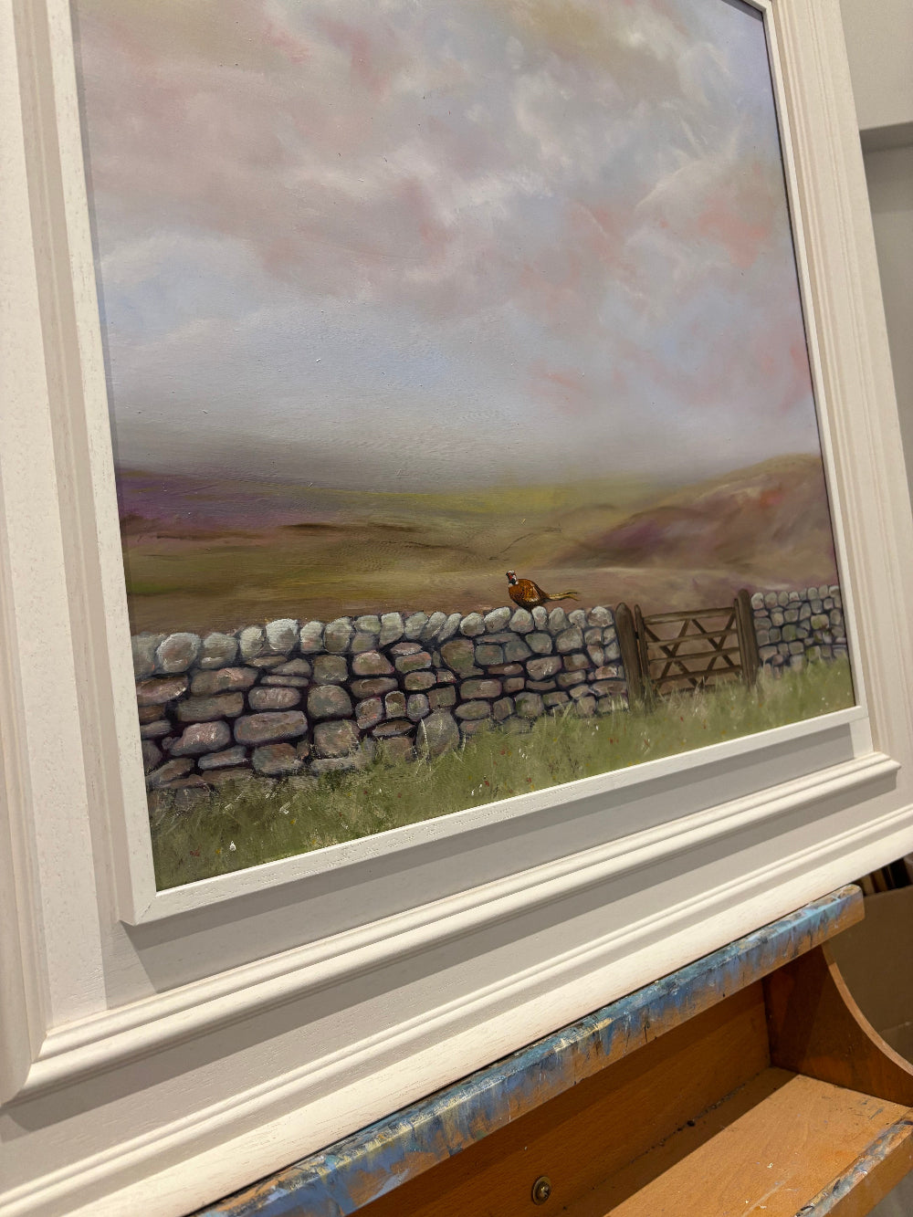 Framed artwork of a stone wall and landscape