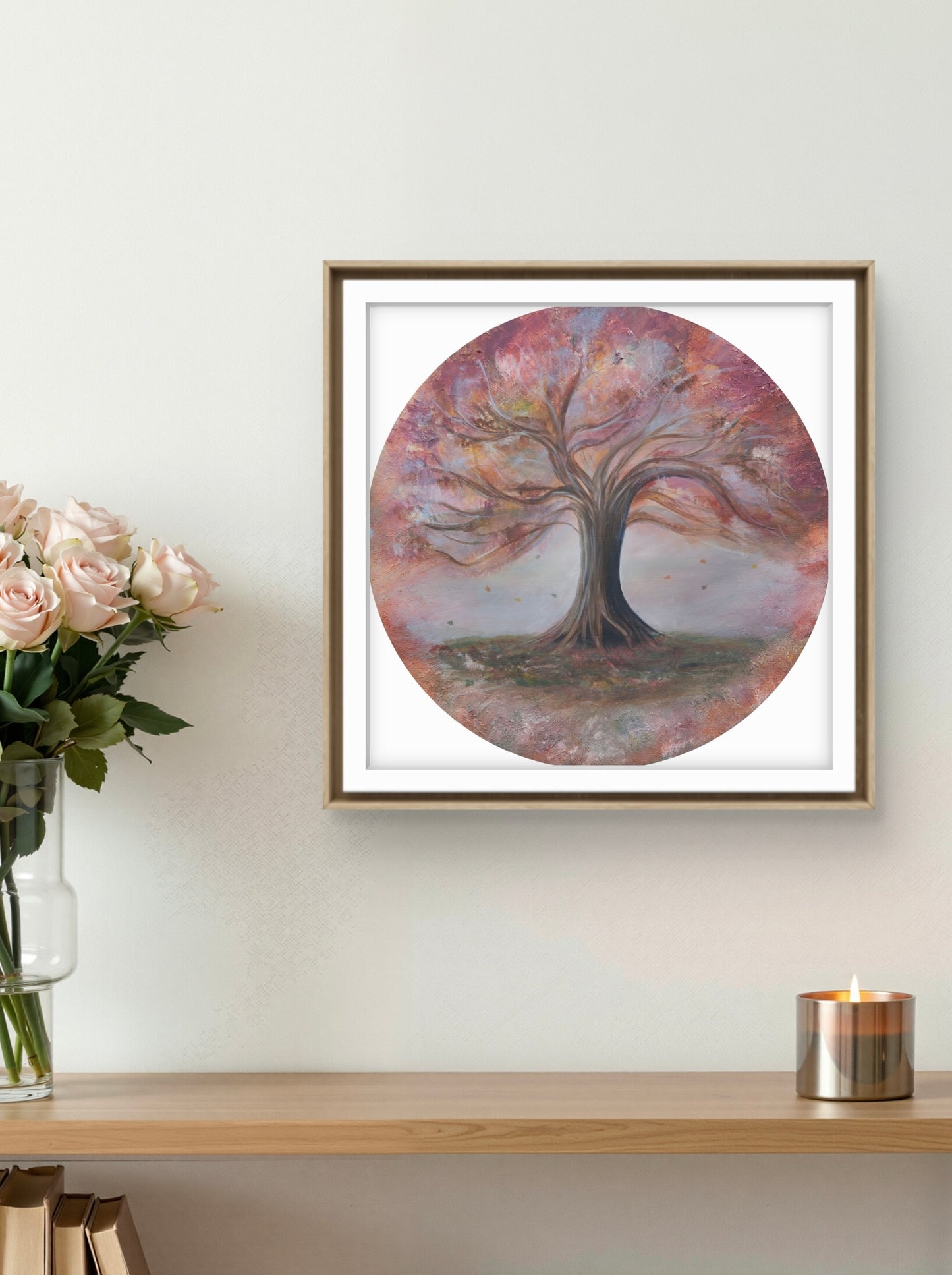 Framed artwork of a tree on a wall above a shelf with flowers and a candle.