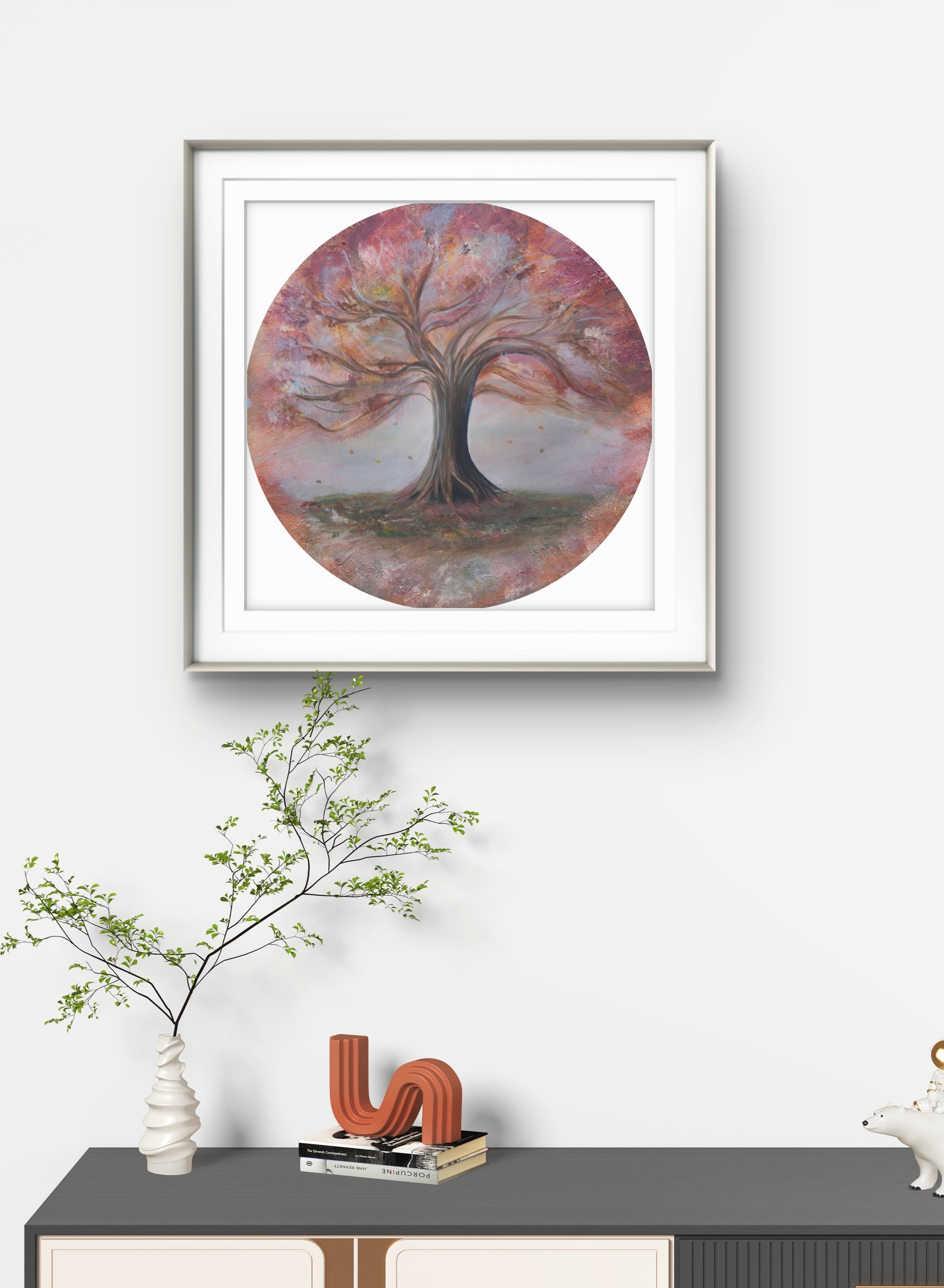 Framed artwork of a tree on a wall above a console table with decorative items.