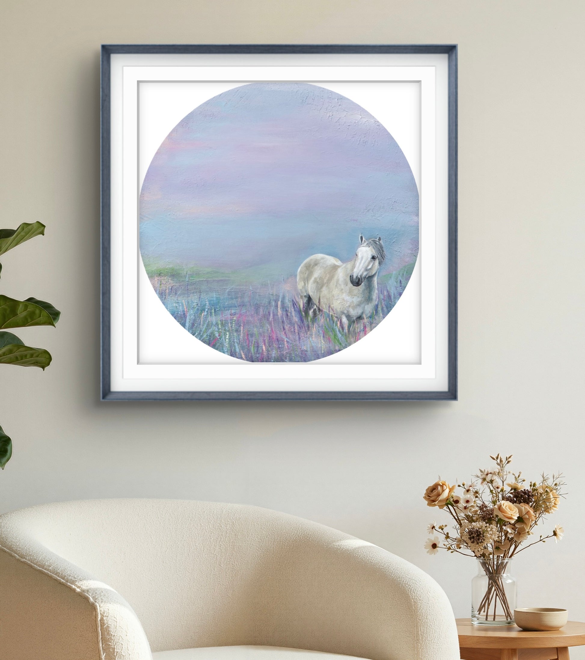 Framed artwork of a horse in a field on a wall above a sofa.