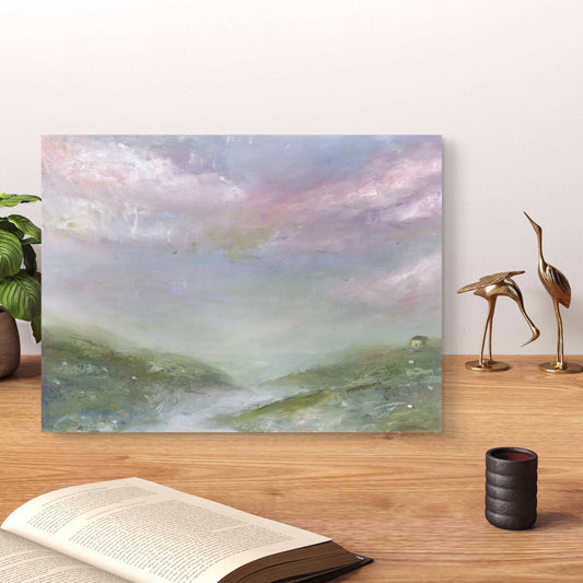 Scenic painting on a wall above a wooden surface with decorative items.