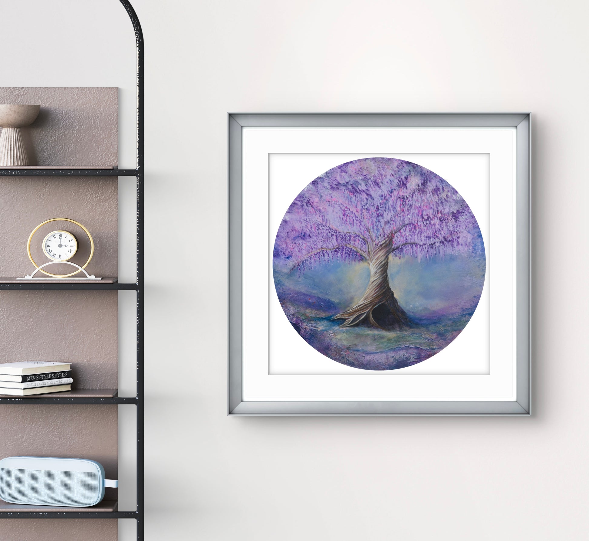 Framed circular artwork of a tree with purple foliage on a white wall next to a shelf.