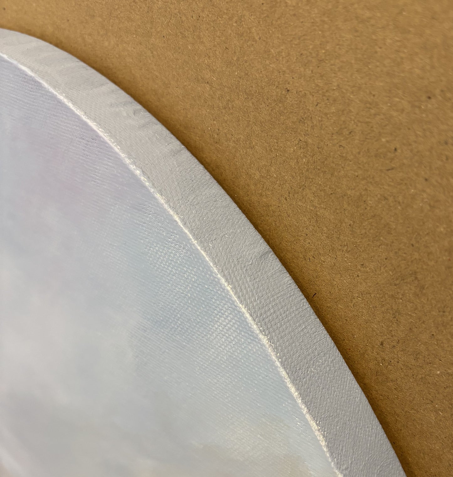 Close up of a circular  Canvas edge shown painted light blue 