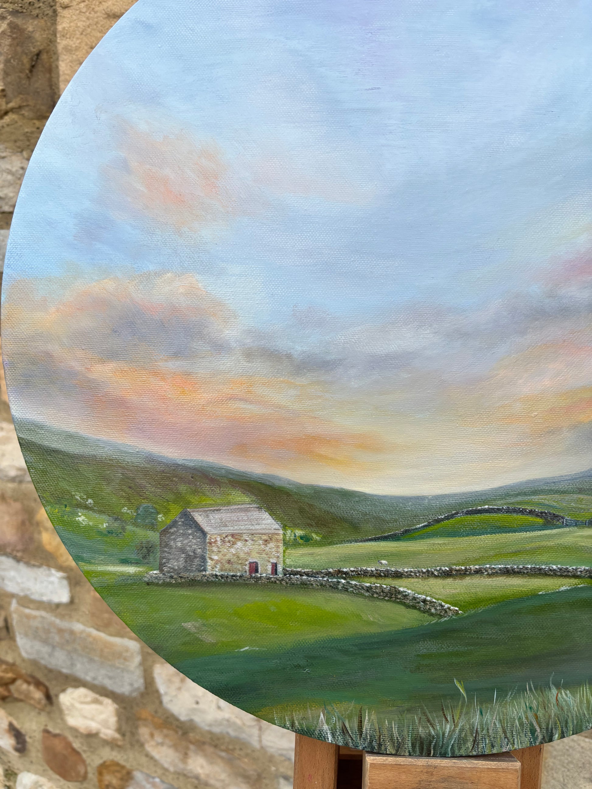 Painting of a landscape with a stone building and green fields.