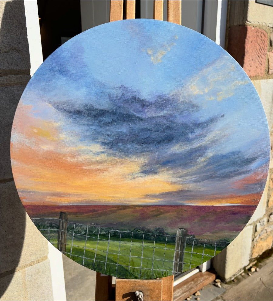 Painting of a landscape with a sky transitioning from orange to blue, displayed outdoors.