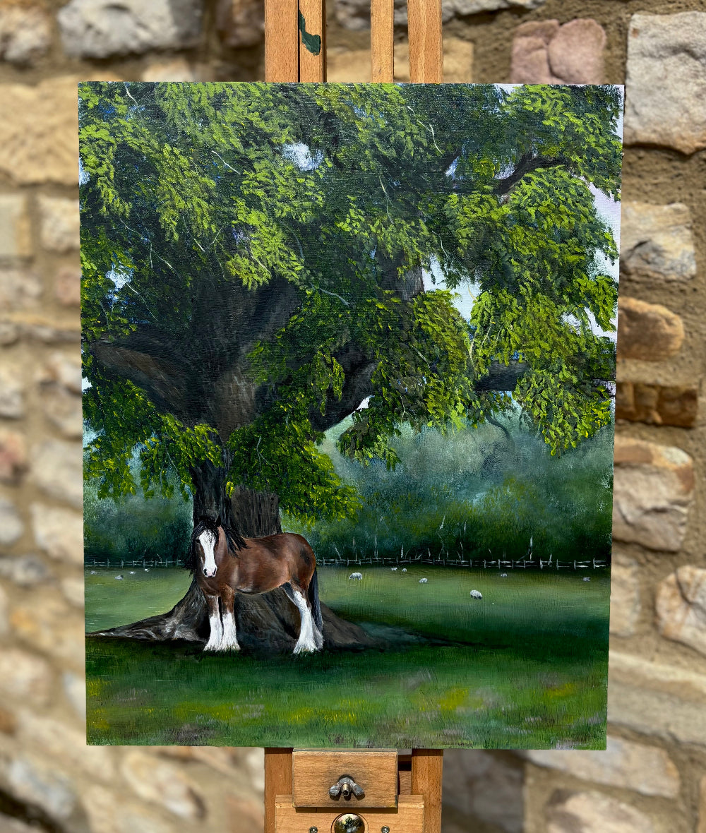 Painting of a horse under a tree on an easel against a stone wall background